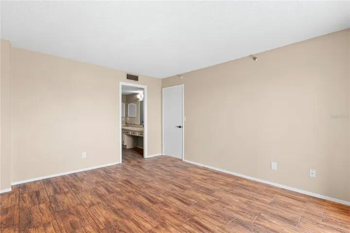 Owners Suite 1 with dressing area, full bathroom with walk-in closet, tub, loo and vanity.
