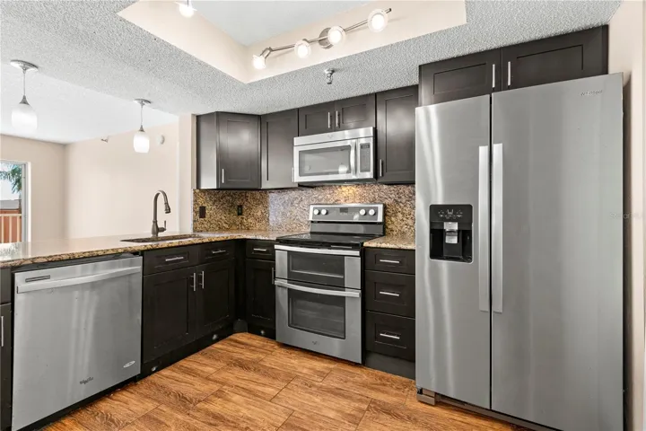 Wood mission style cabinetry with stainless appliances.