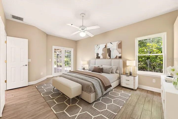 The generous primary suite has double entry doors and French doors that access the lanai. Virtually Staged.