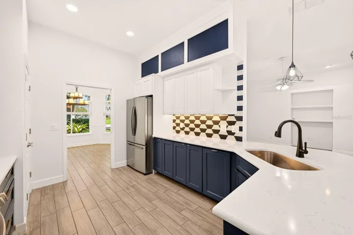 The stunning KITCHEN RENOVATION (2024) features QUARTZ COUNTERTOPS, ceiling-height cabinetry, STAINLESS STEEL APPLIANCES, a stylish backsplash, and a chic modern color palette.