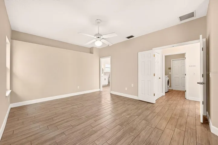 The generous primary suite has double entry doors and French doors that access the lanai.