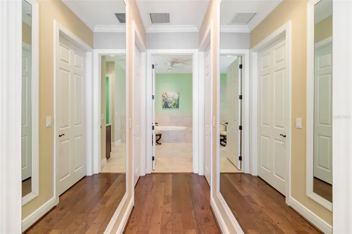 Hallway to ensuite bathroom with mirrors on both sides of wall