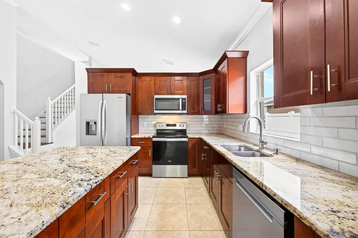 Designed with the home chef in mind, the kitchen features Whirlpool appliances, GRANITE COUNTERTOPS, rich oak cabinetry, a prep ISLAND with storage, and a pantry.