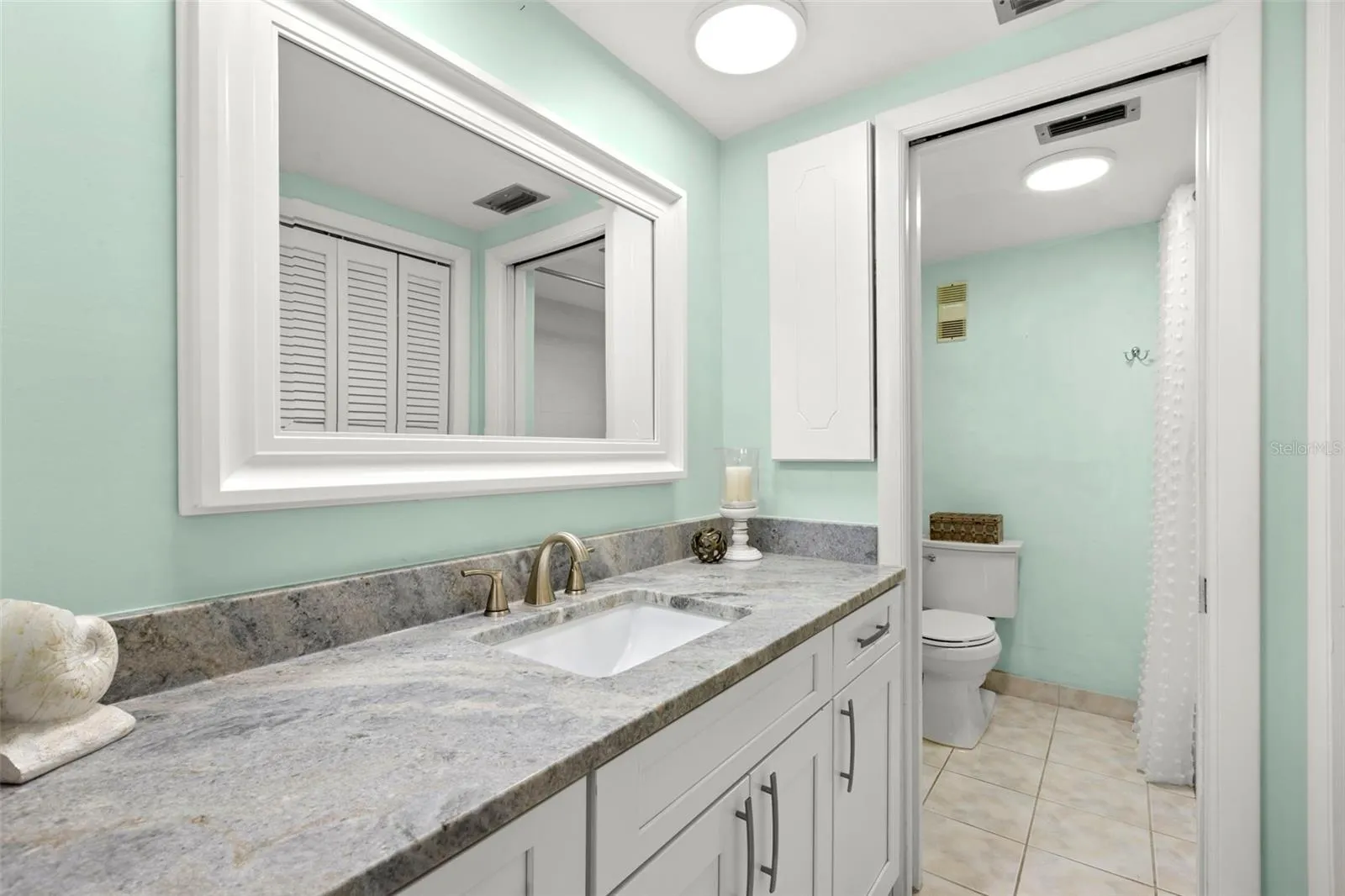 Bedroom 1 ensuite bath with dual sinks, dual closets, tub/shower combo and loo.