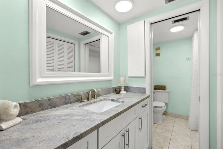 Bedroom 1 ensuite bath with dual sinks, dual closets, tub/shower combo and loo.