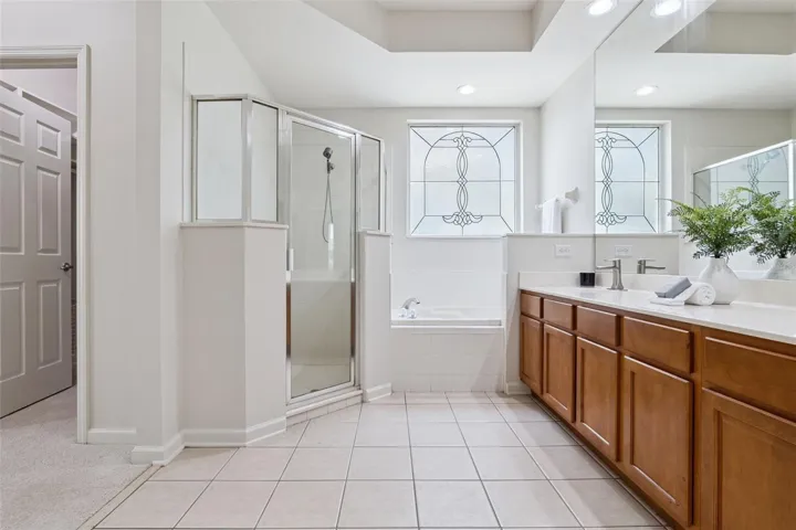 Primary Bathroom w/ glass enclosed walk-in shower & soaking tub