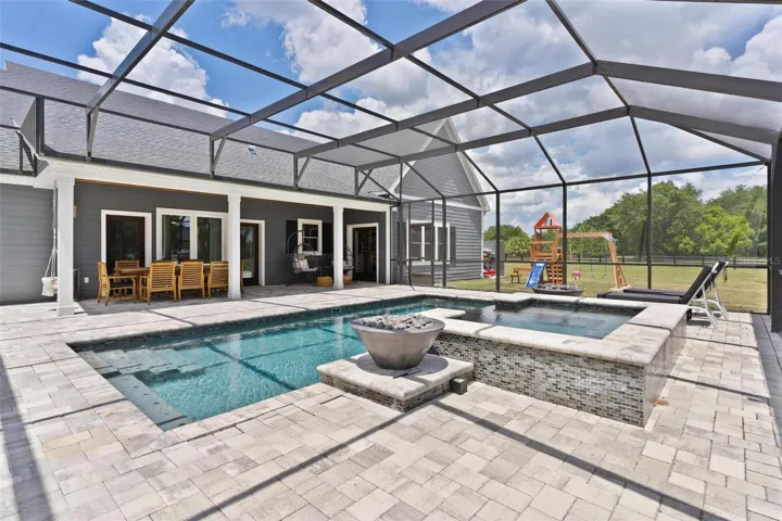 Outdoor living reaches another level w/ the spectacular screened saltwater pool & spa. Spend your days relaxing in the pool, unwind in the hot tub, or gather around one of the 2 fire pits that beautifully frame the spa area