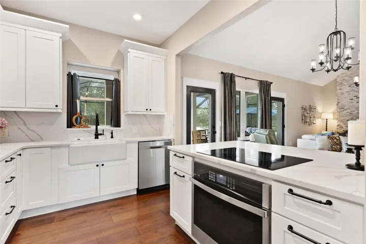 Kitchen is both functional & beautiful, featuring quartz countertops, full-height designer backsplash, stainless appliances, & an island perfect for preparing meals or gathering.