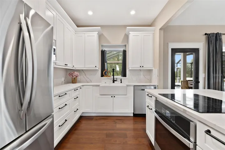 Kitchen is both functional & beautiful, featuring quartz countertops, full-height designer backsplash, stainless appliances, & an island perfect for preparing meals or gathering.