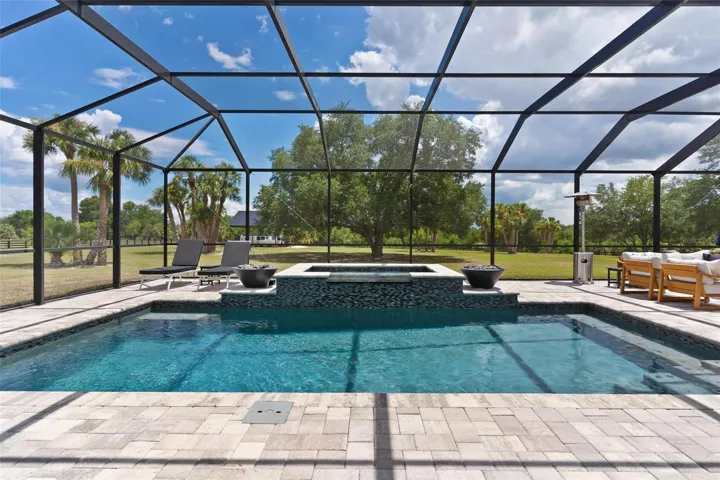 Outdoor living reaches another level w/ the spectacular screened saltwater pool & spa. Spend your days relaxing in the pool, unwind in the hot tub, or gather around one of the 2 fire pits that beautifully frame the spa area