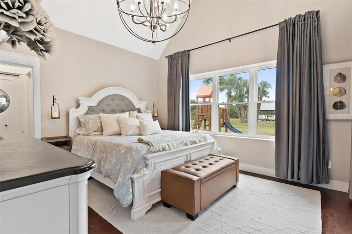 Primary Suite features high ceilings, French door leading to pool area, and Old English Wood flooring.