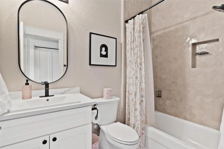 Bathroom #3 features quartz countertops and shower/tub combo