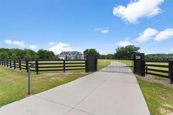 4.2 beautifully fenced acres & surrounded by 4-board fencing and electric gated entry