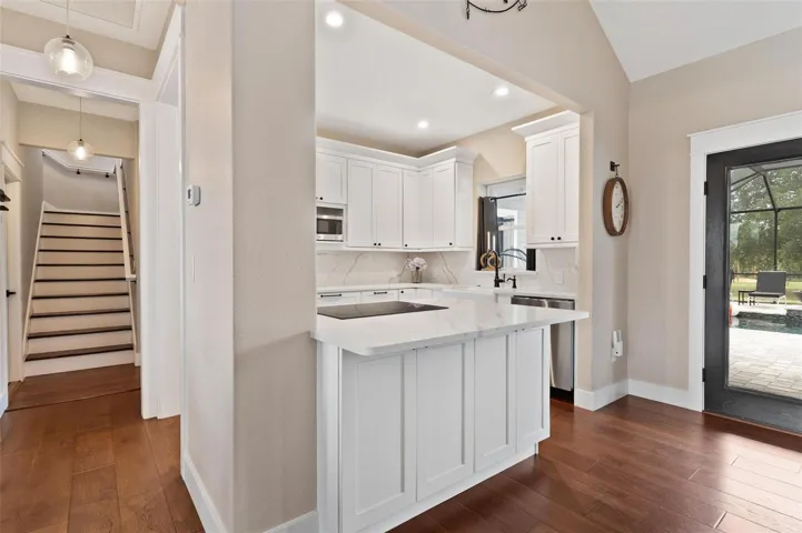 Kitchen is both functional & beautiful, featuring quartz countertops, full-height designer backsplash, stainless appliances, & an island perfect for preparing meals or gathering.