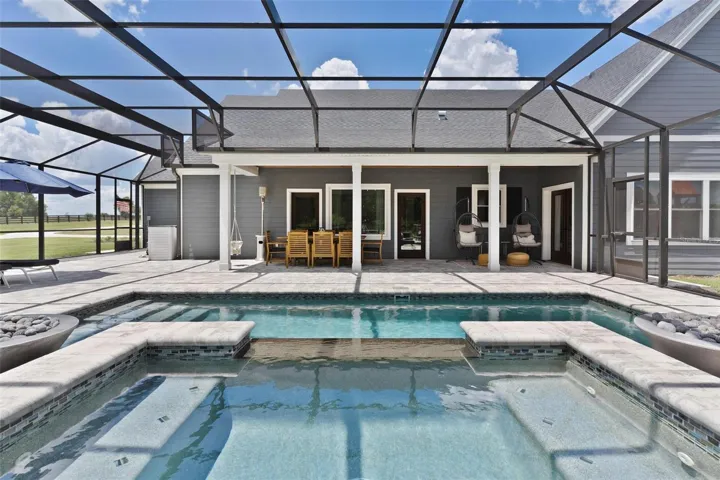 Outdoor living reaches another level w/ the spectacular screened saltwater pool & spa. Spend your days relaxing in the pool, unwind in the hot tub, or gather around one of the 2 fire pits that beautifully frame the spa area
