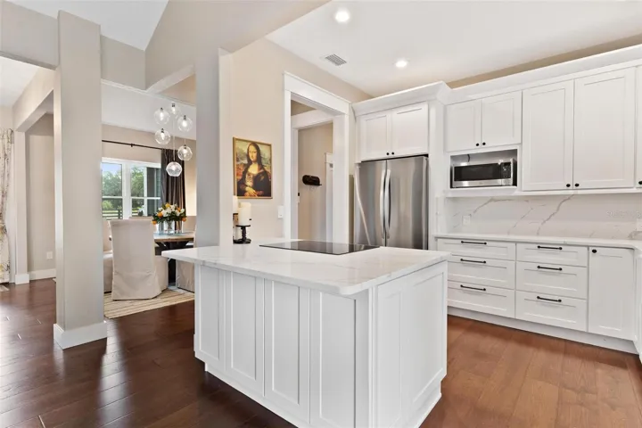 Kitchen is both functional & beautiful, featuring quartz countertops, full-height designer backsplash, stainless appliances, & an island perfect for preparing meals or gathering.