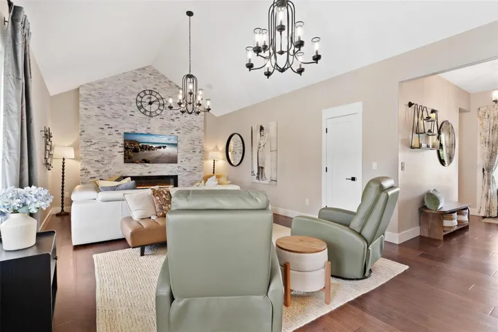 Anchoring the great room is a stunning floor-to-ceiling rock accent wall featuring an LED fireplace, creating a beautiful focal point & cozy gathering space.