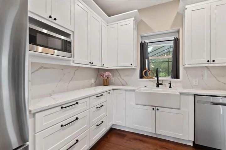Kitchen is both functional & beautiful, featuring quartz countertops, full-height designer backsplash, stainless appliances, & an island perfect for preparing meals or gathering.
