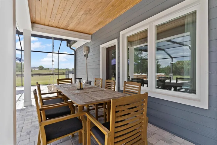 Covered Patio by the pool feature tongue and groove ceilings.