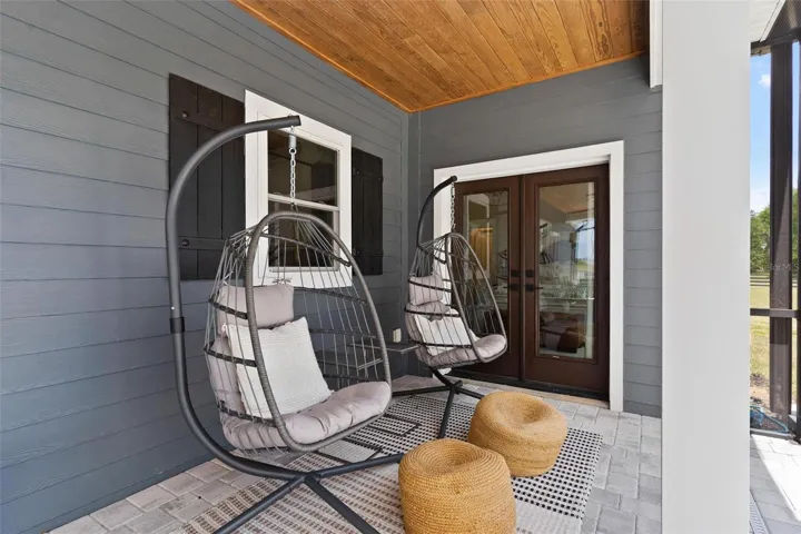 Covered Patio by the pool feature tongue and groove ceilings.