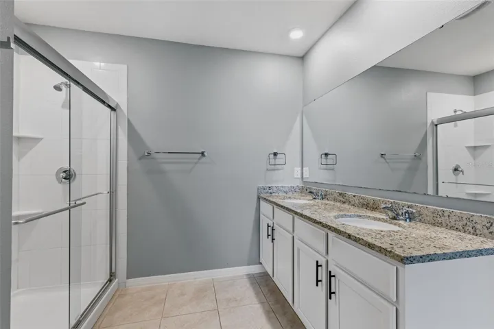 Granite countertops, dual vanity & a large tiled shower in your primary bath