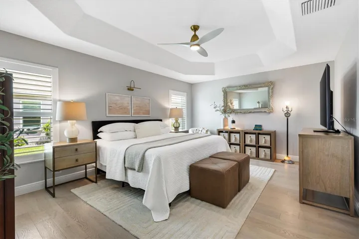 PRIMARY BEDROOM W/TRAY CEILING AND PLANTATION SHUTTERS