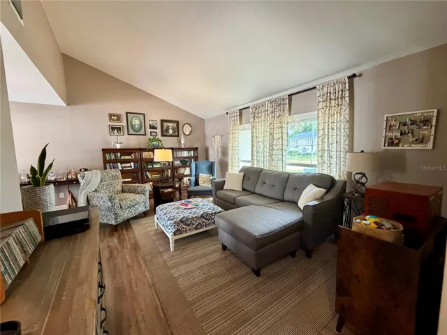 Formal living room with vaulted ceilings adjacent to the dining room
