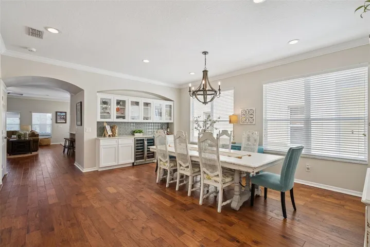 Formal Dining Room with custom built-in buffet with glass-front cabinetry, wine storage, and decorative tile backsplash