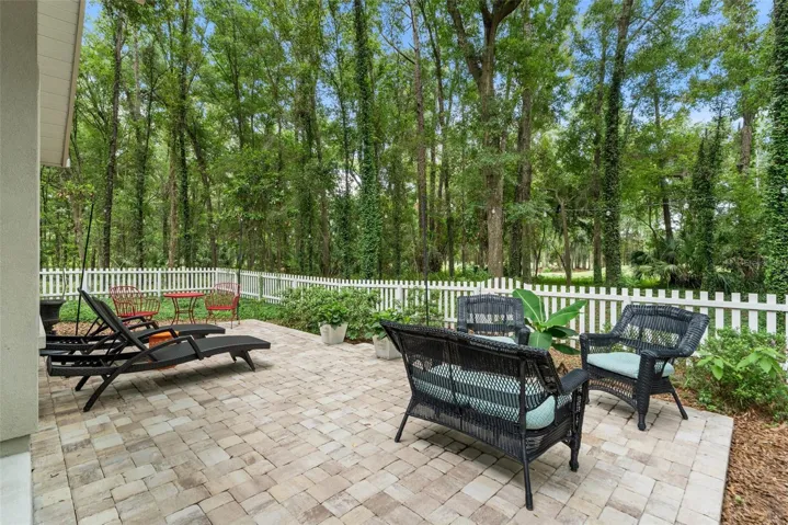 Pavered patio overlooking woods and fairway