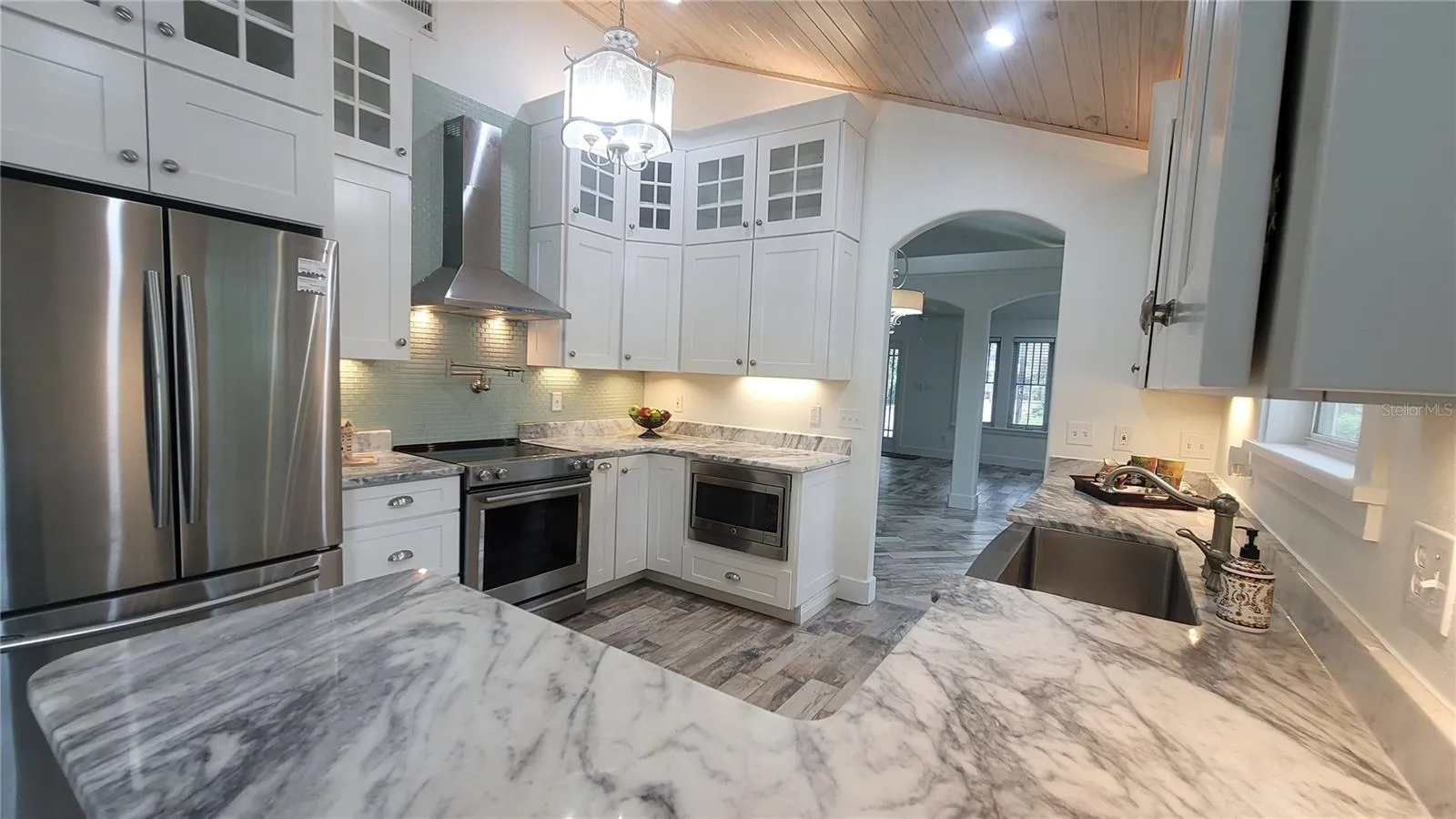 WOW! Gotta love this kitchen - tall tall ceilings, gourmet touches all around, LOTS of beautiful cabinets and counter space. Layered custom lighting for a great At-Home feel.
