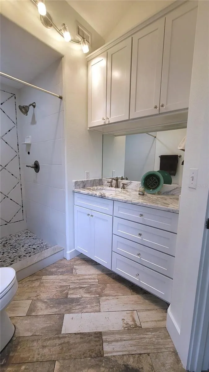 Full bath in your workspace or studio - custom lighting, lots of cabinets and GIANT walk-in shower