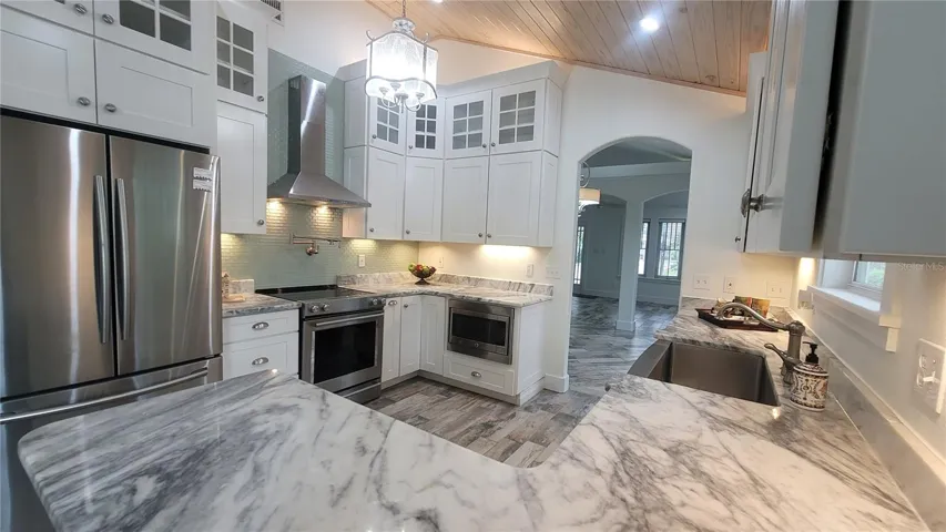 WOW! Gotta love this kitchen - tall tall ceilings, gourmet touches all around, LOTS of beautiful cabinets and counter space. Layered custom lighting for a great At-Home feel.