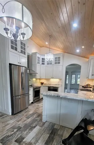 Layered custom lighting in your gourmet kitchen. SS Appliances