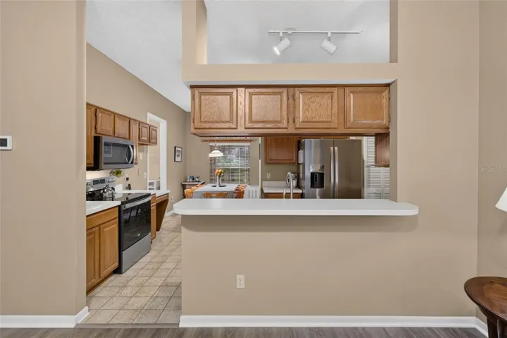 Kitchen w/ wood cabinetry & breakfast bar.