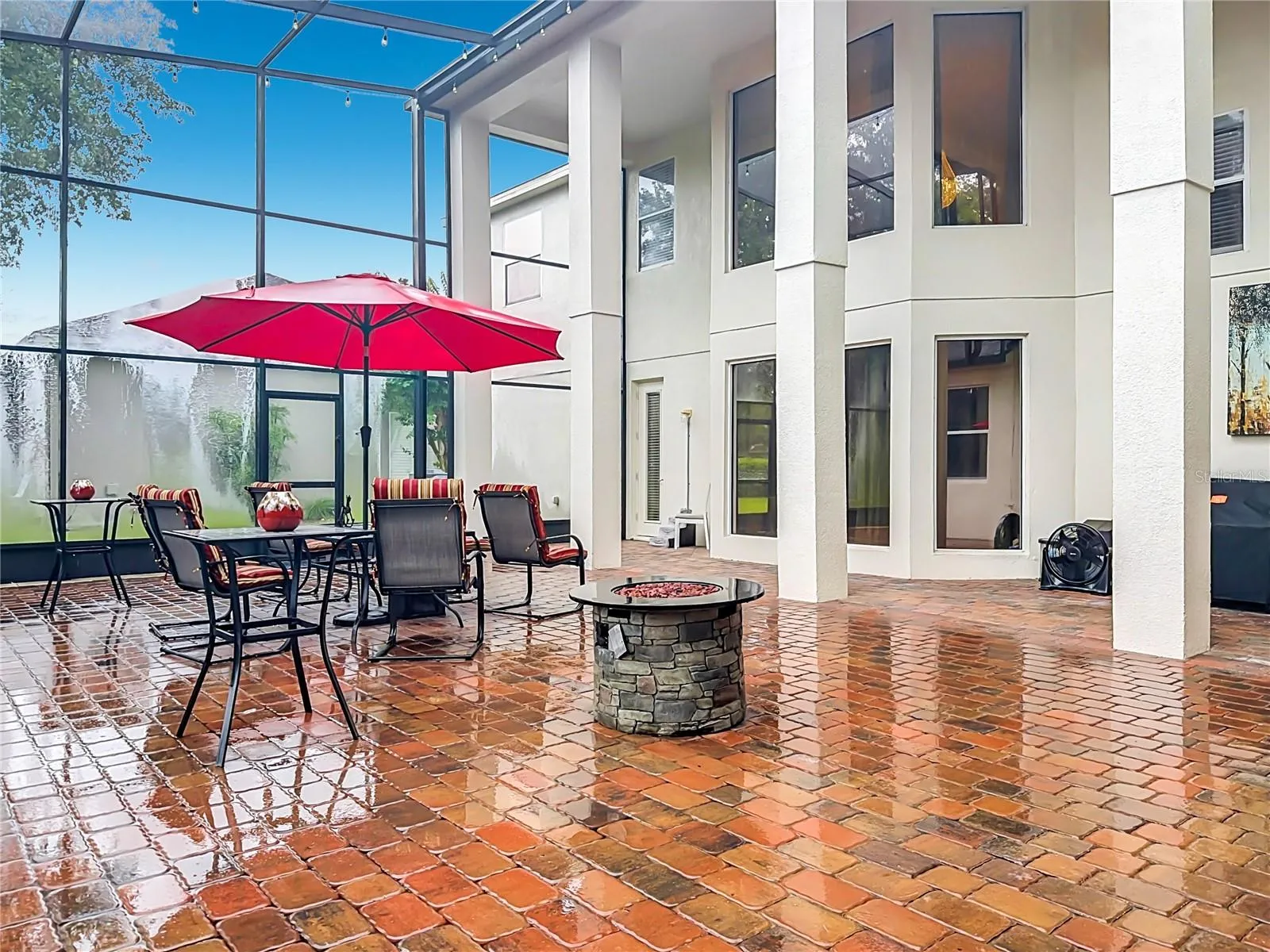Outdoor living area. 2-story screen enclosure with paver flooring. Door access to downstairs bath