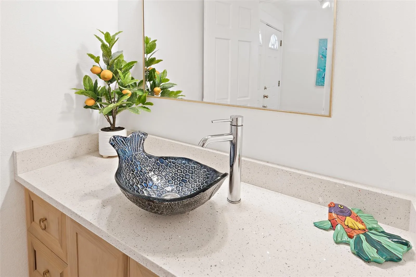 Powder bathroom vessel sink with Quartz countertop, wood-tone cabinetry and chrome faucet
