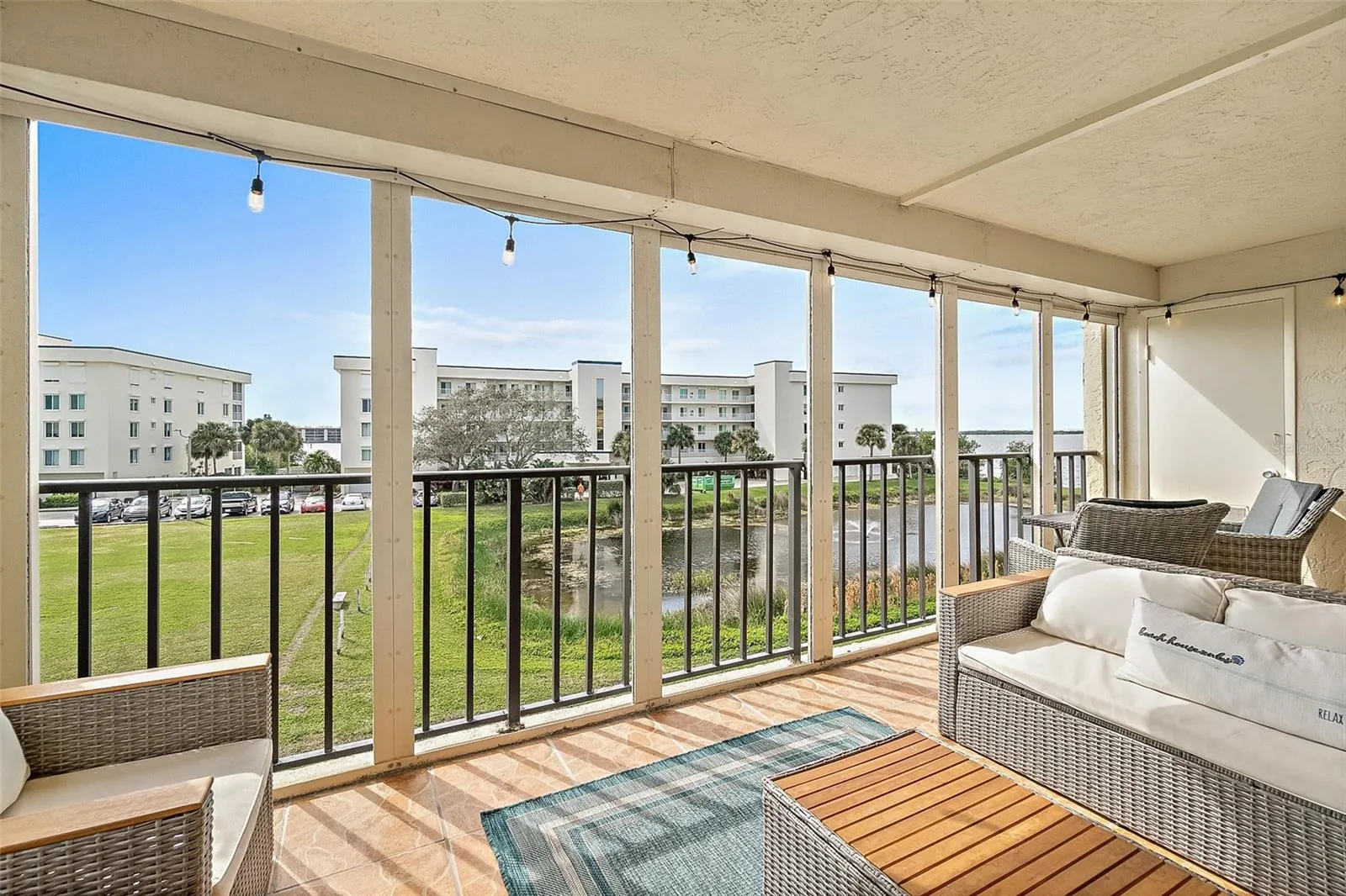 Balcony with seating area, electric storm shutters and direct pond view, Riverwest condo, Cocoa Beach, Florida