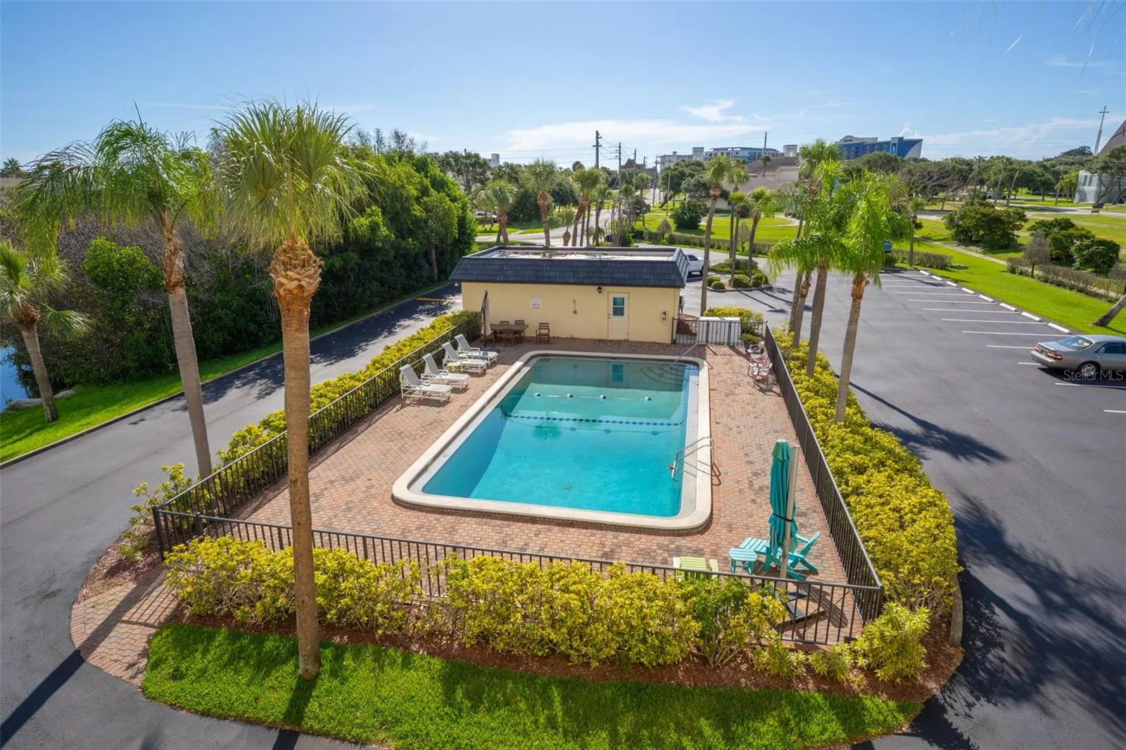 Riverwest community pool with brick paver deck and palm trees — Cocoa Beach, Florida condo association