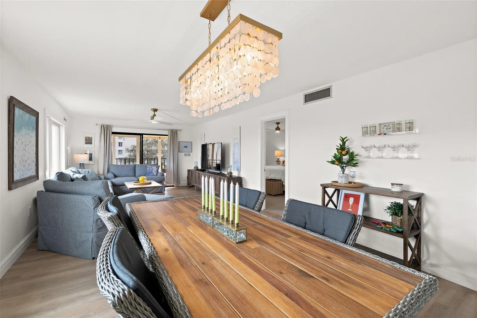 Open-concept dining and living area with capiz shell chandelier, Banana River condo, Cocoa Beach
