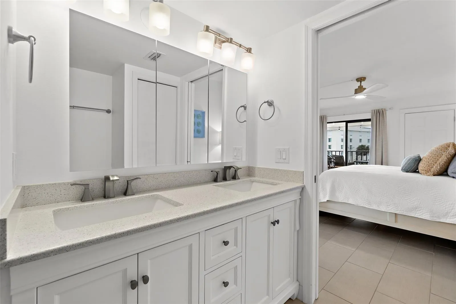 Primary bathroom dual vanity with quartz countertop and view into bedroom, Riverwest condo
