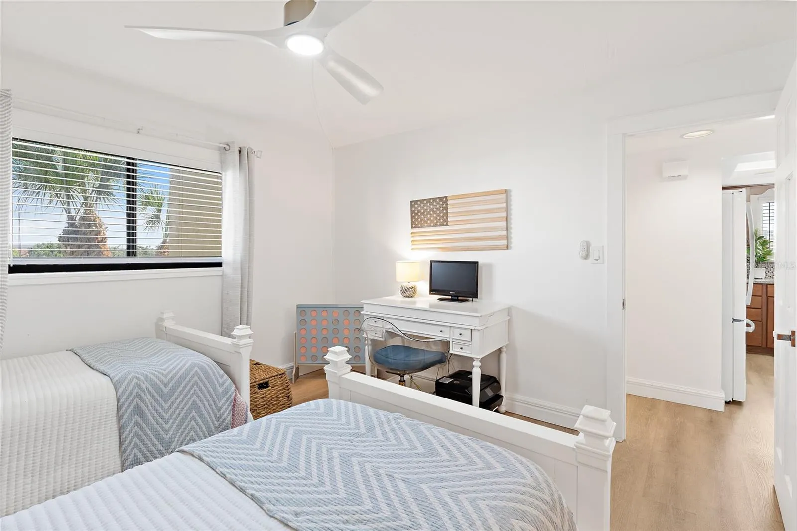 Guest bedroom with desk, ceiling fan, and natural light — Riverwest condo, Cocoa Beach