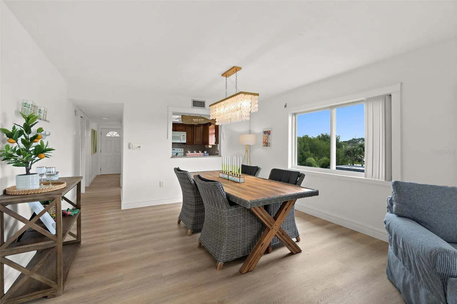 Open-concept dining area with wood-look flooring and pendant chandelier, Riverwest condo, Cocoa Beach