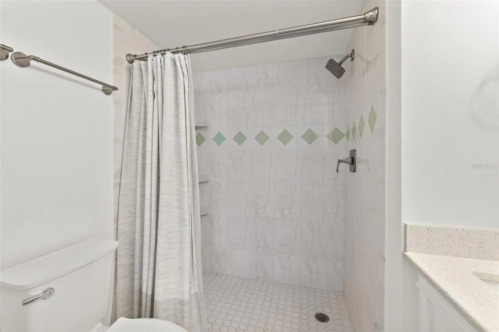 Primary bathroom walk-in tile shower with decorative accent tile, Riverwest condo, Cocoa Beach