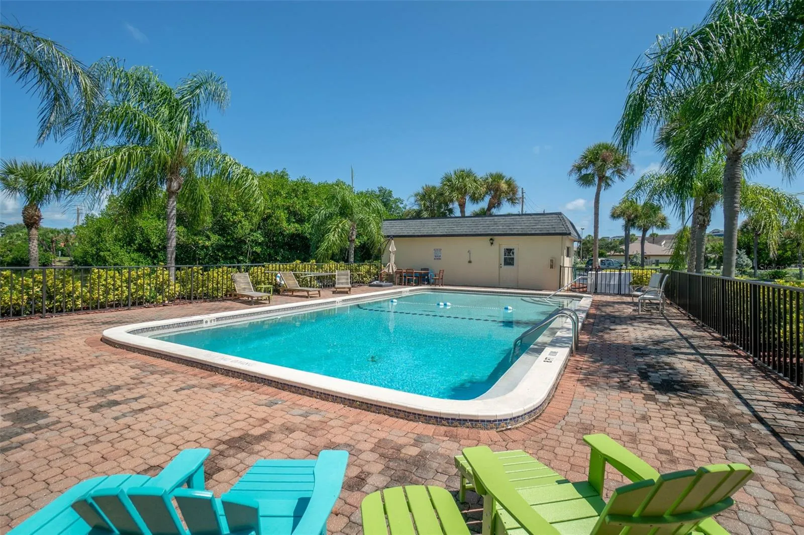 Riverwest community pool deck with colorful lounge chairs and palm trees, Cocoa Beach, Florida