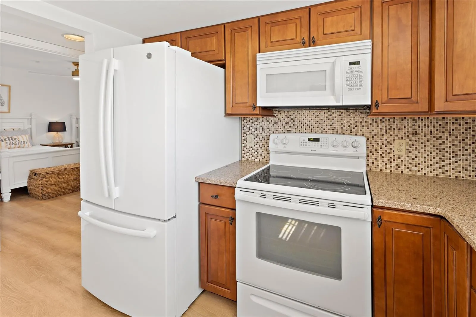 Kitchen with white French-door refrigerator, electric range and granite countertops — Cocoa Beach condo