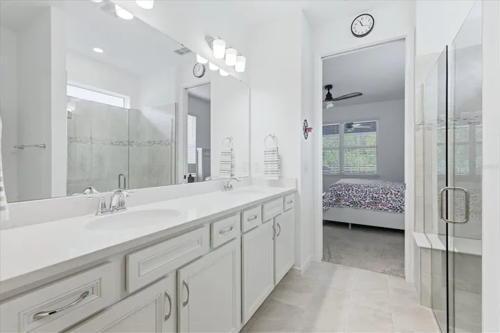 Primary bath with dual sinks and frameless glass shower surround