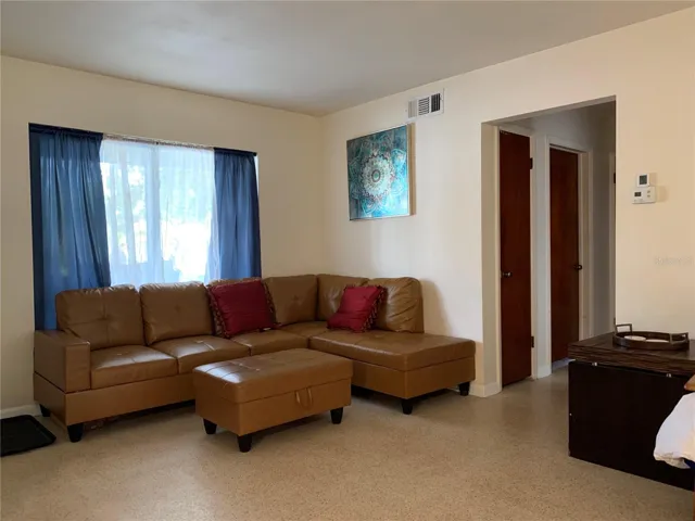 Leather sectional seating. The front porch and swing are on the other side of the big window.