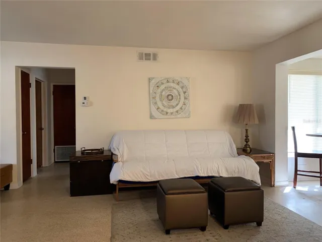 Full size pullout futon. The hallway leads back to the primary bedroom on the left. The first door on the left in the hall is the utility closet; second door on left is the primary bedroom; door with vent in the bottom houses the brand new AC system just installed. Hallway also leads to the second bedroom and the main bathroom, but they are not visible in this shot.