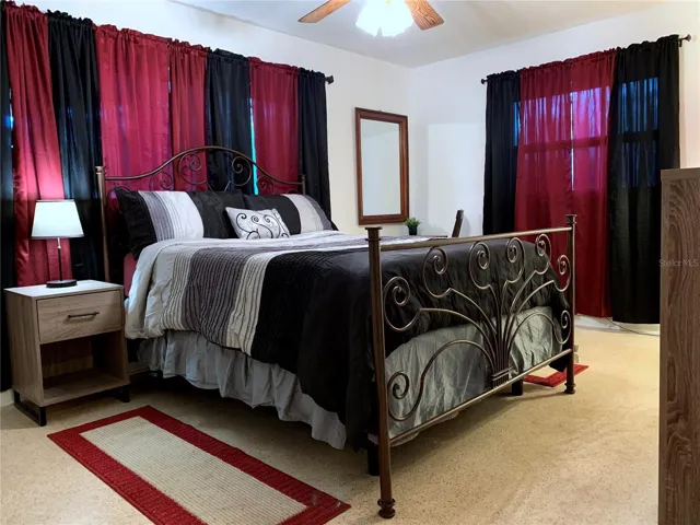 Primary bedroom with Queen bed; terrazzo floors throughout the house help keep the place nice and cool. In the far corner is a table for make-up with chair and mirror.