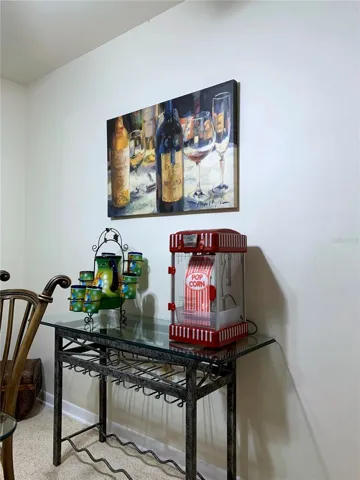 Console table with popcorn machine, and wine bottle, wine glasses storage.